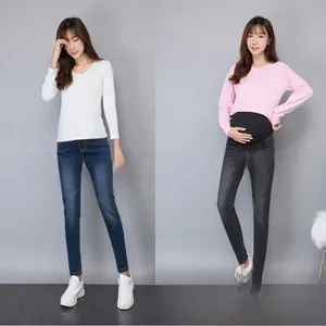 Detail view of maternity denim trousers with high elastic black belly support waistband