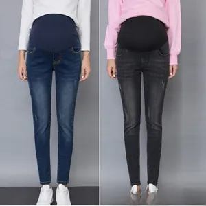 Detail view of maternity jeans with high waist elastic belly band in blue and grey