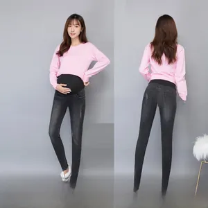 Detail view of maternity skinny jeans featuring an elastic high-waist support belly band