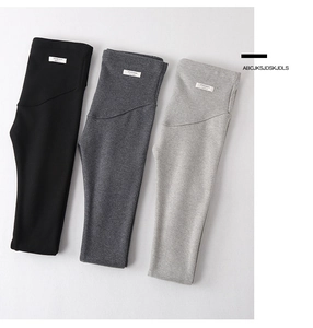 Close-up of three colors of maternity leggings with high waist support and woven labels