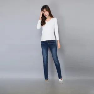 Detail of slim-fit maternity jeans with high waist support and white long sleeve V-neck top