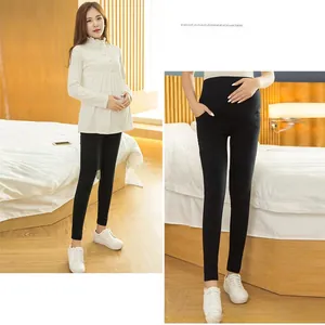 Detail of high waist maternity leggings and ruffled long sleeve top for pregnant women