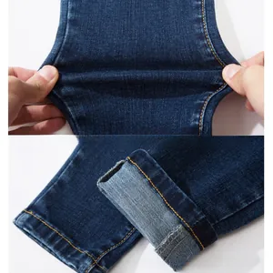 Close-up of stretchy dark blue maternity jeans featuring elastic fabric and hem detailing