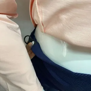 Detail of adjustable waist band with elastic strap and button on maternity leggings