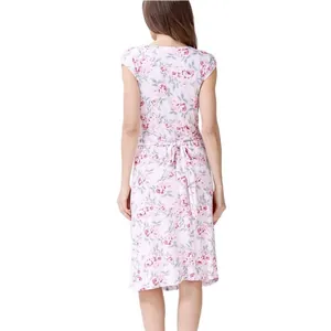 Détail du dos d'une robe de maternité fleurie avec un nœud rose ajustable à la taille