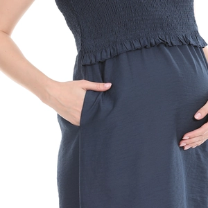 Close-up of navy blue maternity dress featuring smocked chest detail and side pocket