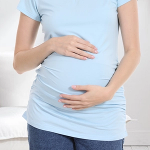 Detail of light blue maternity T-shirt with side ruching and elastic fabric texture