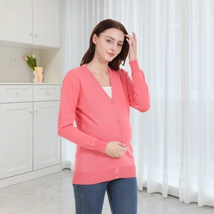 Detail of pink knitted maternity cardigan featuring V-neckline and matching buttons