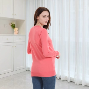 Detail of pink long sleeve maternity knit cardigan with ribbed cuffs in a home setting