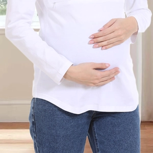 Dettaglio della maglia premaman in cotone bianco con zip nascosta per l'allattamento