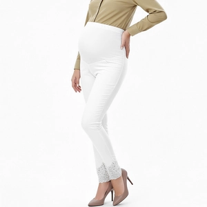 Detailaufnahme weißer Umstandsleggings mit hoher Taille und feiner Spitze am Beinsaum