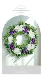 Close-up of artificial hydrangea and violet wreath with green leaves on light background
