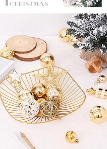 Detail of gold and white Christmas ball set inside a wire star basket on a festive tray