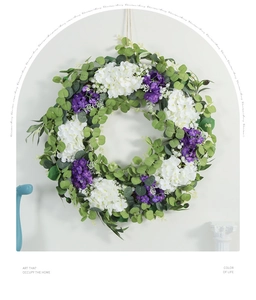 Detail of artificial spring wreath with eucalyptus leaves and purple violets on white wall