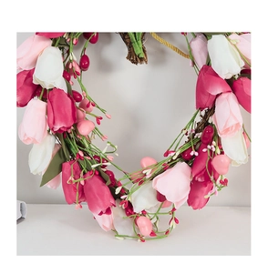 Close-up of heart-shaped tulip wreath with pink flowers, berries and rattan base