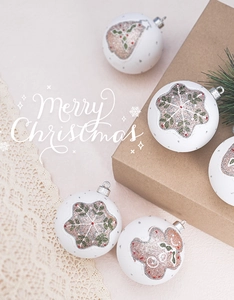 Detailed view of white Christmas ornaments with glitter gingerbread man and snowflake patterns