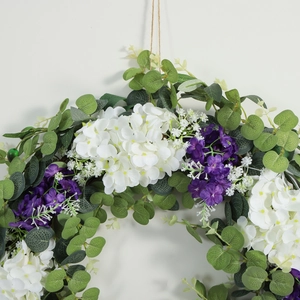 Artificial spring wreath with green leaves, purple violets and white hydrangeas for wall decor