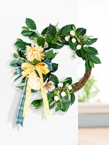 Close-up of yellow dahlia and white rose wreath with elegant blue and yellow ribbons
