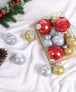 Festliche Weihnachtsugeln in Rot, Gold und Silber mit Glitzer auf weißem Plüschteppich