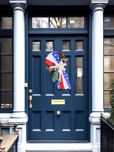 Detail of 4th of July wreath with stars, stripes, ribbons and berries on blue door