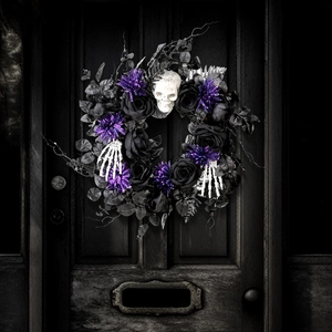 Close-up of Halloween wreath featuring black roses, a white skull and skeleton hands