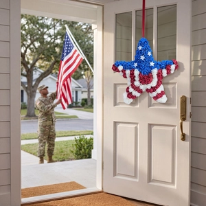 Patriotic star wreath with red white and blue foam roses hanging on a wooden door