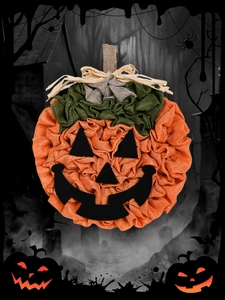 Detailed view of handmade burlap pumpkin wreath with textured ruffles and festive face