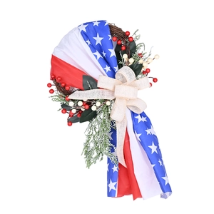 Patriotic 4th of July wreath with red white blue stars berries and burlap bow on rattan