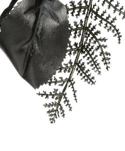 Detail of silk-textured black leaves and glittered fern branch for Halloween decor
