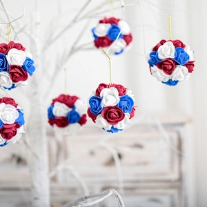 Close-up of patriotic red white and blue rose flower balls with gold hanging strings