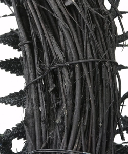 Close-up of black wooden branches and wire binding on a Halloween bat wreath decoration