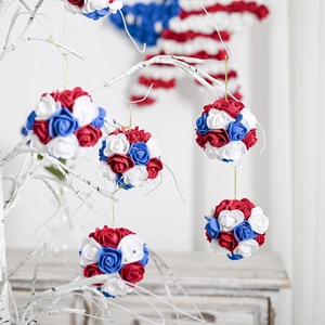 Patriotic red, white and blue rose ball ornaments hanging on branches for indoor decoration