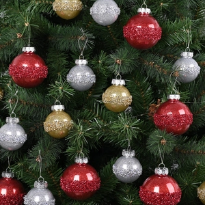 Weihnachtskugel-Set mit Glitzerperlen in Rot, Gold und Silber an grünen Tannenzweigen