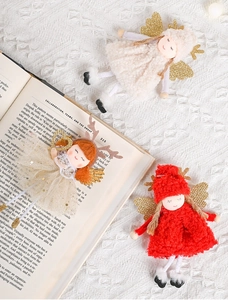 Dettaglio di angeli di Natale in peluche con ali di pizzo e corna su libro vintage