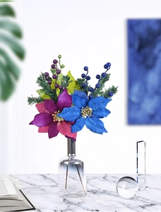 Close-up of glittered blue and purple artificial poinsettias in a glass vase for decor