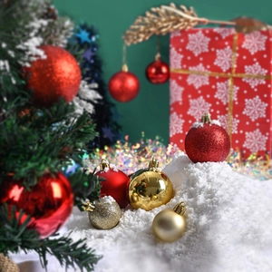 Red and gold Christmas ball ornaments in shiny, matte and glitter finish on snow