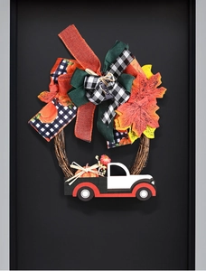Close-up of fall harvest wreath with maple leaves, burlap bows and a vintage truck sign