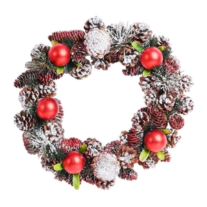Close-up of pine cones and red balls on a Christmas wreath with artificial snow finish