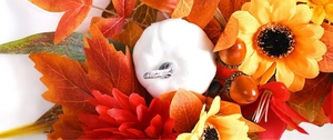 Macro detail of white pumpkin with autumn maple leaves and sunflowers on harvest wreath