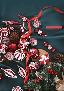 Detail of red and white striped Christmas ornaments and candy decor on green silk