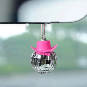 Disco ball car ornament with a bright pink cowboy hat hanging on a rearview mirror