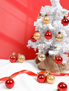 Glossy red and gold Christmas ball ornaments on a snowy flocked tree branch