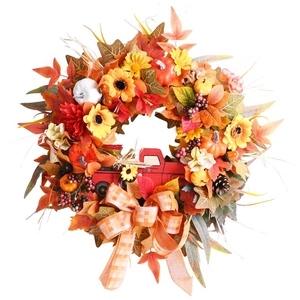 Detail of autumn wreath with maple leaves, sunflowers, pumpkins, and red truck decor