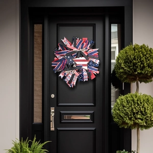 Couronne patriotique du 4 juillet avec rubans rouge blanc bleu sur une porte d'entrée noire