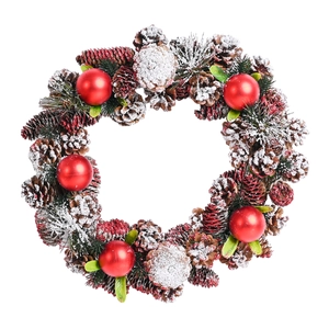 Snow-covered Christmas wreath with natural pine cones, red ornaments and green pine needles