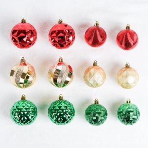 Set of 12 multi-textured Christmas ornaments in red, gold, and green on white fur base