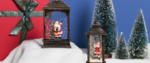 Close-up of retro bronze Christmas lanterns with Santa Claus and festive snow scene