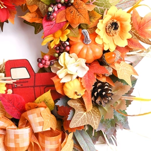 Autumn wreath with sunflowers, maple leaves, pumpkins, and a red wooden truck on white background