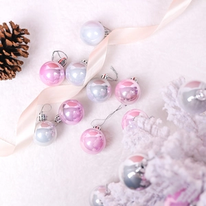 Pink and silver pearlescent Christmas tree ball ornaments on a soft white fur backdrop