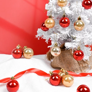 Red and gold glossy Christmas baubles with golden strings on a festive background